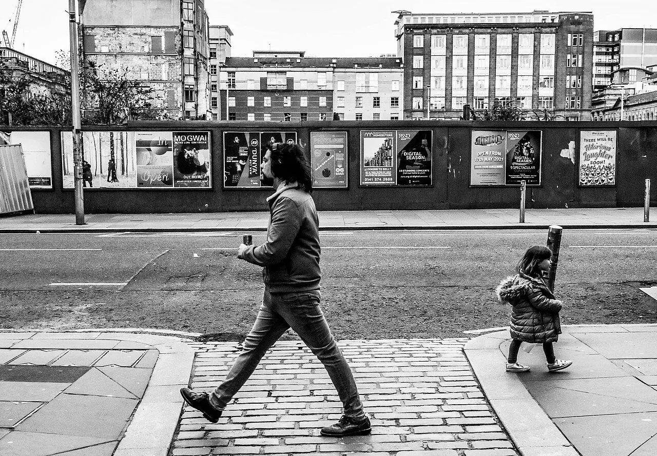 Walker's trainers on a pavement mid-stride