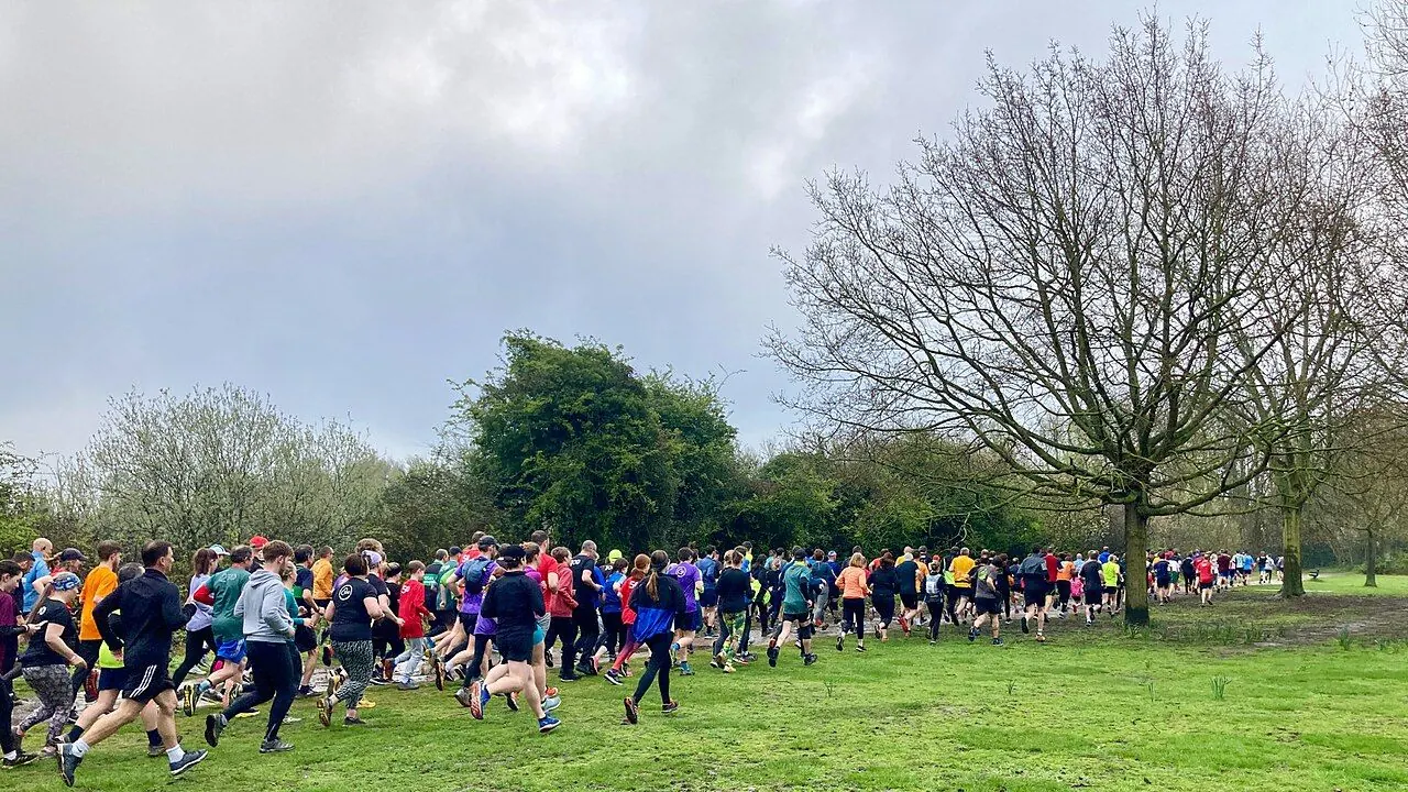 Runners and walkers on a park path at a parkrun